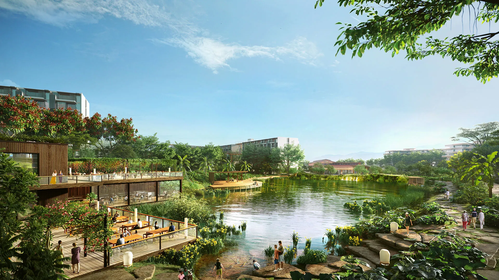 Laguna Lakelands Waterfront Villas - A serene lakeside with people leisurely walking and sitting, amidst lush greenery, under a clear sky with modern buildings.