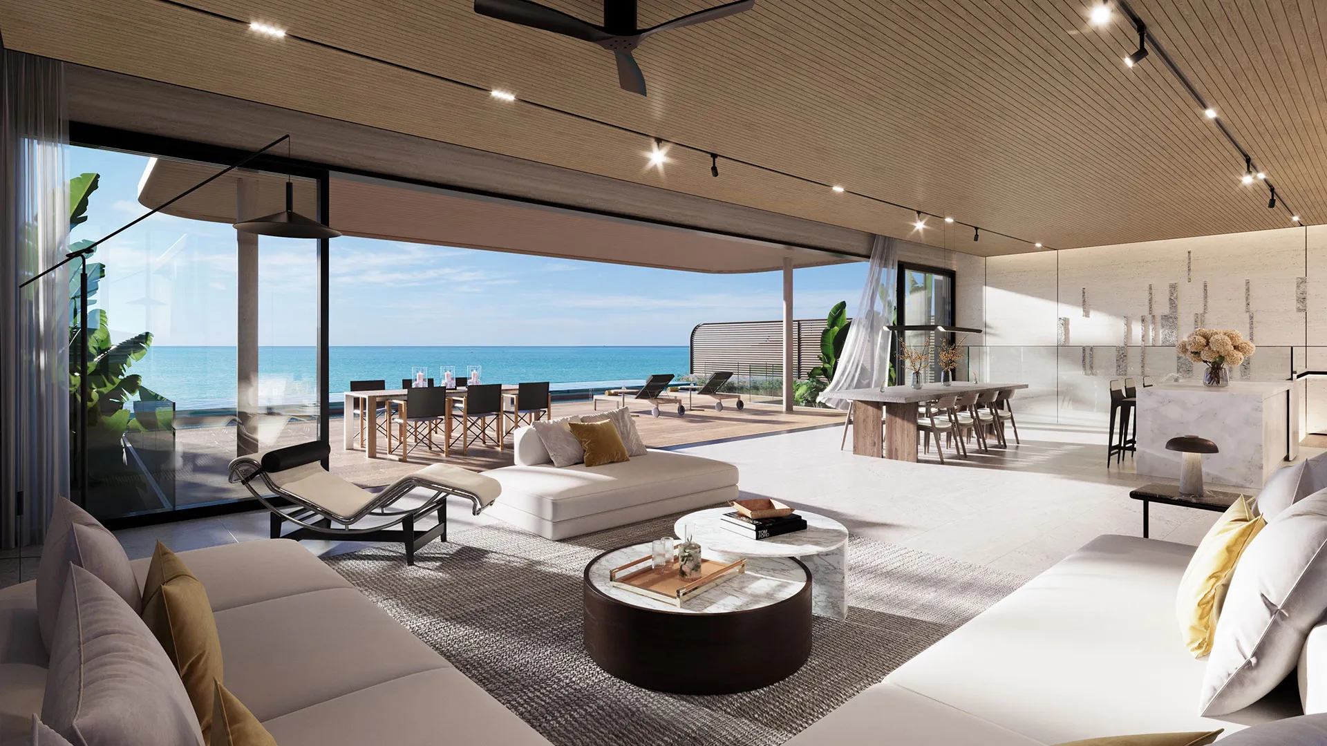Banyan Tree Beach Residences Mazu - A beachfront living space with glass walls, comfortable furniture, a dining area, and a view of the ocean under a clear sky.